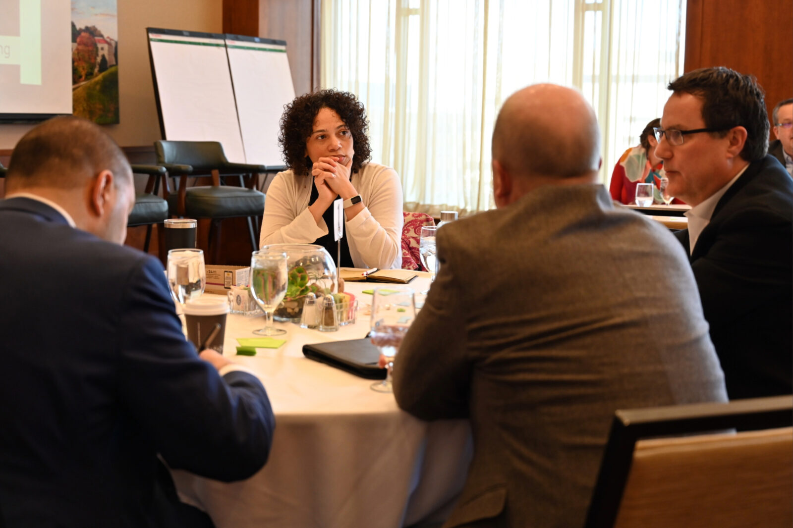 A group of people has a discussion at a table.
